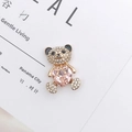 Detail eines Goldbären-Anhängers mit glitzernden Strasssteinen und rosa Herz-Edelstein - Rosa Bär