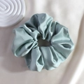 Close-up of light blue silk satin scrunchie showing glossy texture on soft fabric - Light Blue