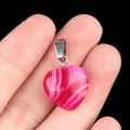Pendentif coeur en agate rose naturelle avec bélière métallique tenu dans la main - Agate rouge rose