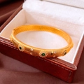 Detail eines vergoldeten Vintage-Armreifs mit grünem Smaragd und Zirkonia auf Leder - Gold-Grün (Echtgold Vergoldet)