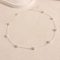 Detailed view of fresh water pearl necklace with silver chain and lobster clasp on beige texture - Silver Chain White Pearl / Silver