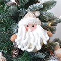 Detailansicht von Plüsch-Weihnachtsmann-Deko mit Glöckchen an einem Weihnachtsbaumzweig - Beige Kamel Weihnachtsmann