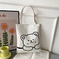 Detail of white canvas tote bag with black line art cartoon bear in a lifestyle setting - White with Sleeping Bear