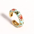 Detailed macro view of light blue enamel ring with red and white floral patterns - Light Blue