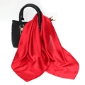 Detail of red satin scarf draped over a black leather handbag with a high-shine finish - One Size / Faux Silk Satin / Red