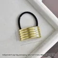 Macro detail of U-shaped gold alloy hair ring with dimensions 5cm x 2.5cm on white velvet - Gold Glossy Five Rings