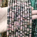 Close-up of flat disk natural stone spacer beads with unique pink and black patterns - Black Line Pink Stone