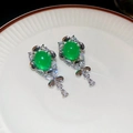 Detail view of vintage green orb earrings with white zircons on a ceramic tray - Oval Green Stone Halo Tassel (30#)