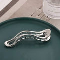 Silberne gewellte Haarspange aus Metall auf einem luxuriösen Keramikteller - Glattsilber