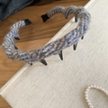 Detail of gray knitted headband with gold thread texture on a vintage book surface - Blue Gray