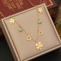 Detail der goldenen Kleeblatt-Kette mit Türkis-Akzenten und Herzen auf einer Box - Kleeblatt Herz Türkis Stil