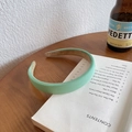 Minimalist mint green padded sponge headband with a textured fabric finish on a book - Thickened Padded Fabric Style / Light Green