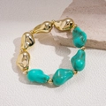 Close-up of bohemian acrylic beaded bracelet with golden irregular beads and teal stones - Blue