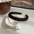Handmade black sponge headband with red bow patterns on a ceramic display - Black Bow