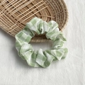Chic green and white plaid fabric scrunchie displayed on a rustic woven tray - Green Plaid