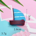 Macro view of blue and brown resin sailboat charm with 3cm x 2.8cm dimensions - Blue Sailboat