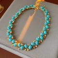 Macro-opname van een vintage gouden ketting met turquoise stenen en glanzende stras - Ketting - Goud - Blauw