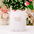 White Highland cow plush toy with long fur and pink flower crown in home setting - White