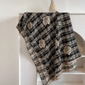Elegante sciarpa beige e nera con motivo a rose e frange esposta su scaffale bianco - Nero