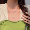 Elegant bow and pearl pendant necklace in silver finish worn by a fashion model - Butterfly Pearl Accent (X1239) / Silver/White Pearl