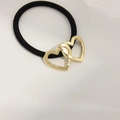 Elastic hair tie featuring double interlocking golden metal hearts on a black band - Hollow Double Heart Gold