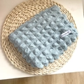 Light blue bubble textured cosmetic pouch for makeup and phone storage on a mat - Bubble Storage Bag - Smog Blue