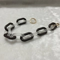 Close-up of brown acrylic chunky chain with gold spring ring clasps on plush background - Frosted Black Brown