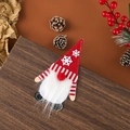 Gros plan du range-couverts gnome rouge et blanc avec décor de Noël sur bois - Style Flocon de Neige