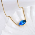 Golden box chain necklace featuring a blue marquise-cut crystal pendant on shell background - Pisces