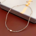 Primer plano de collar con cuentas grises facetadas, perla de agua dulce y cierre dorado - Blanco (Caja de Regalo)