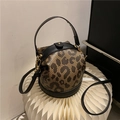 Chic leopard print bucket bag with black leather trim and adjustable shoulder strap - Black