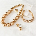 Detailed view of elegant gold pearl jewelry set with necklace, bracelet and earrings - Gold Champagne
