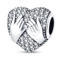 Macro shot of silver heart charm with hands clasped over shimmering clear crystals - Holding Hands Zircon Heart Bead