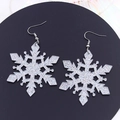 Sparkling silver snowflake drop earrings with glitter finish on a black display plate - Christmas Snow