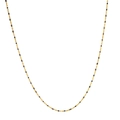 Dettaglio della collana a catena dorata con piccole perle nere su sfondo bianco puro - Oro con perline nere