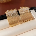 Detail von vergoldeten Quastenohrringen mit Zirkonia-Besatz auf Leder-Schmuckständer - 925 Silberstift / Kupfer / Quastenohrstecker (Echt Vergoldet) / Gold