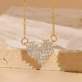 Collier cœur pixel doré avec zircons présenté sur un support minimaliste en pierre - Cœur Mosaïque / Doré