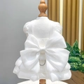 Detail of pet wedding dress showing large organza bow and metal D-ring for leash attachment - White