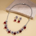 Makroansicht von Schmuckset mit roten Kristallen, Blumenkette und Ohrringen auf Stein - Halskette-Rot / Rot