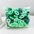Close-up of green cotton hair bands in a transparent bag for toddlers - Green