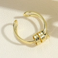 Detailansicht eines goldenen Wellenrings mit vier gleitenden Metallperlen - Dekompressions-Mehrkreisring