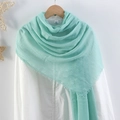 Solid light turquoise pleated cotton linen scarf with frayed edges hanging on a white shirt - Pale Turquoise