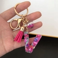 Detail of resin letter V keychain with pink shell flakes, gold ring and tassel - Small Ball Tassel Clasp / Letter V