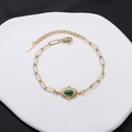 Vintage gold-tone stainless steel chain bracelet featuring an oval green stone centerpiece - Green Oval Gemstone-Sunburst Frame