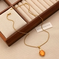 Detailed shot of gold stainless steel necklace with orange gemstone in a jewelry box - Gold Orange Gemstone Necklace Style (S471)
