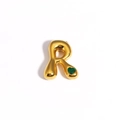 Macro d'un pendentif lettre R dorée avec une pierre précieuse verte en forme de cœur - Lettre R / Or / Gemme Coeur Vert