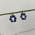 Primer plano de pendientes de aro de acero inoxidable dorado 18K con cuentas azules - Azul Multifacético