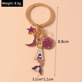 Detail view of a gold keychain with purple enamel mermaid and moon charms with dimensions - Purple
