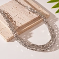 Detailed close-up of multilayer silver chain necklace on stone with natural lighting - 60# Necklace - Silver - Braided Bold Chain