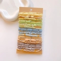 Macro shot of macaron elastic hair ties with gold metal beads on brown card packaging - Concentric Buckle Light Color Set